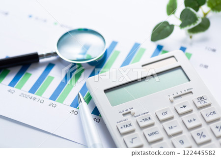 Company performance graph, calculator and magnifying glass 122445582