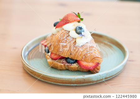 Fresh Strawberry and Blueberry Cream Croissant on a Rustic Ceramic Plate 122445980