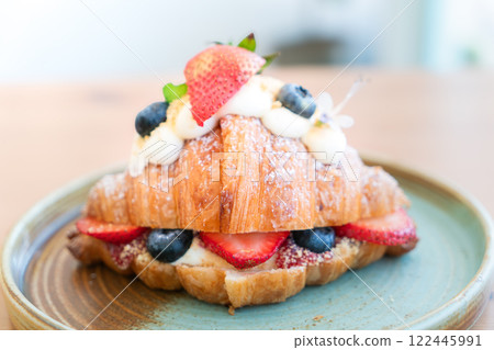 Fresh Strawberry and Blueberry Cream Croissant on a Rustic Ceramic Plate 122445991