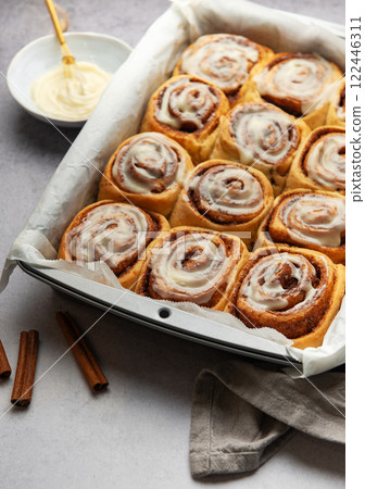 Freshly baked cinnamon rolls with cream cheese frosting in baking pan Freshly baked cinnamon rolls with cream cheese frosting in baking pan 122446311