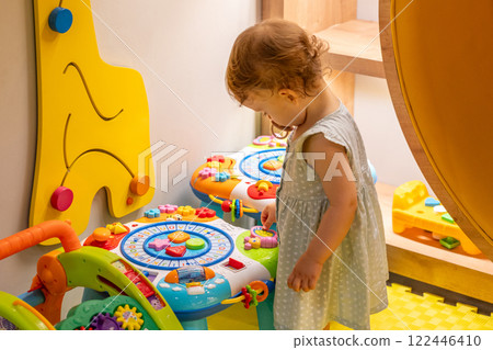 Child focused on an educational toy in a bright room. Concept of early learning and discovery Child focused on an educational toy in a bright room. Concept of early learning and discovery 122446410