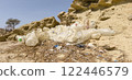 Dump of old plastic scorched by the sun, in the desert, on the background of stones and wood in the desert 122446579