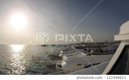 Yachts parked in a row in the sea on a sunny day with glare 122446621
