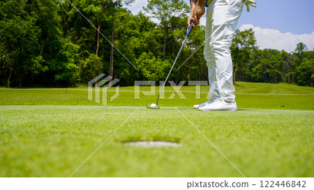 golfer playing golf in the evening golf course, on sun set evening time. 122446842