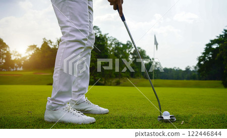 golfer playing golf in the evening golf course, on sun set evening time. golfer playing golf in the evening golf course, on sun set evening time. 122446844