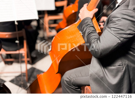 Male musician playing cello in orchestral concert performance Male musician playing cello in orchestral concert performance 122447116