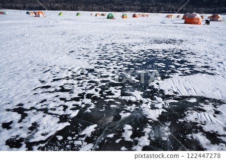 Ice bubbles on the completely frozen Lake Nukabira and a tents for smelt fishing Ice bubbles on the completely frozen Lake Nukabira and a tents for smelt fishing 122447278