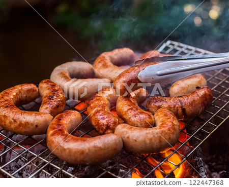 sausage being grilled on Stove 122447368