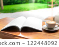 Open Blank Book and Cappuccino on Wooden Table in Cozy Cafe 122448092