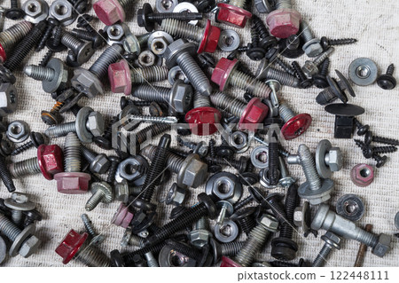 Background of bolts and nuts of different lengths and threads. Industry and production. 122448111