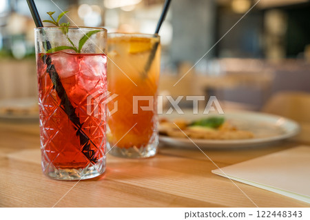 Two mocktails, Cinderella with grenadine and raspberry lemonade, on a wooden table in soft focus 122448343