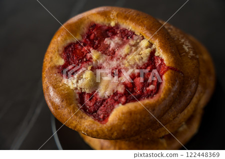 Close-Up of Traditional Czech and Slovak Kolach Pastry with Strawberry Filling on Black Background 122448369