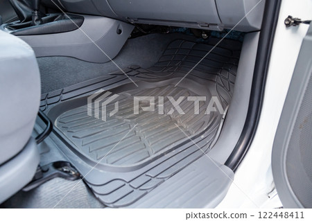 Dirty car floor mats of black rubber under passenger seat in the workshop for the detailing vehicle before dry cleaning. Auto service industry. Interior of sedan. Dirty car floor mats of black rubber under passenger seat in the workshop for the detailing vehicle before dry cleaning. Auto service industry. Interior of sedan. 122448411