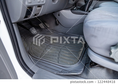 Dirty car floor mats of black rubber under passenger seat in the workshop for the detailing vehicle before dry cleaning. Auto service industry. Interior of sedan. Dirty car floor mats of black rubber under passenger seat in the workshop for the detailing vehicle before dry cleaning. Auto service industry. Interior of sedan. 122448418