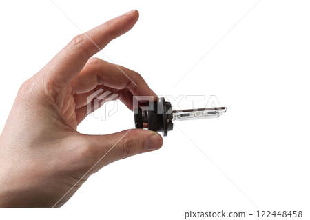 Automotive electric parts - New white 12v xenon headlight car lamp on the white background - gas discharge lamp. Spare parts auto catalog. 122448458