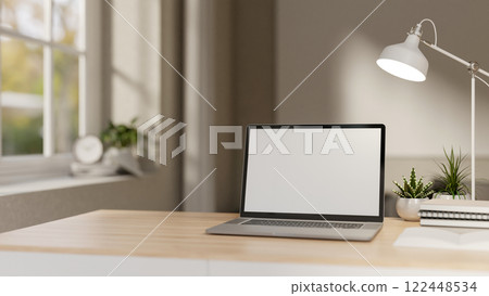 A close-up of a laptop on a minimalist wooden table in a white contemporary room. 122448534