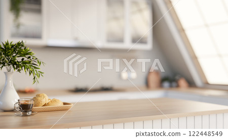 A minimalist hardwood kitchen tabletop adorned with decorative items, set in a sleek white kitchen. A minimalist hardwood kitchen tabletop adorned with decorative items, set in a sleek white kitchen. 122448549