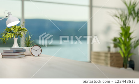 A close-up of a simple hardwood desk with decorative items in a minimalist white room. 122448615