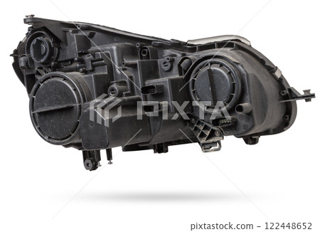 Stylish xenon headlight of a German car - optical equipment with a lamp inside on a white isolated background. Spare part for auto repair in a car workshop. Stylish xenon headlight of a German car - optical equipment with a lamp inside on a white isolated background. Spare part for auto repair in a car workshop. 122448652