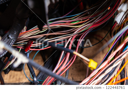 A cable of matted wires of different colors with connectors in the electrical wiring of the car. Internet line in the work of the provider. 122448761