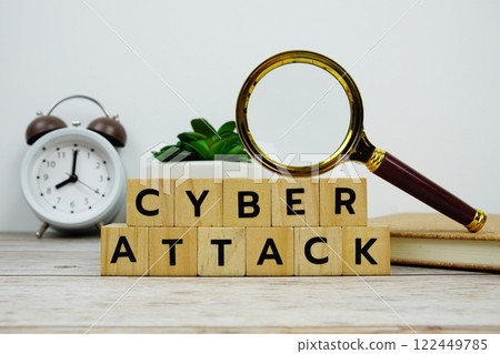 Magnifying glass and alarm clock with wooden blocks alphabet letters CYBER ATTACK text message on wooden background Magnifying glass and alarm clock with wooden blocks alphabet letters CYBER ATTACK text message on wooden background 122449785