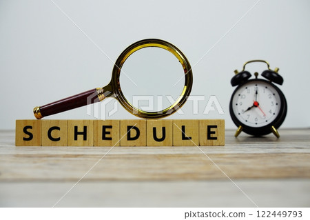 Time to Schedule with wooden blocks alphabet letters and Magnifying glass on wooden background 122449793