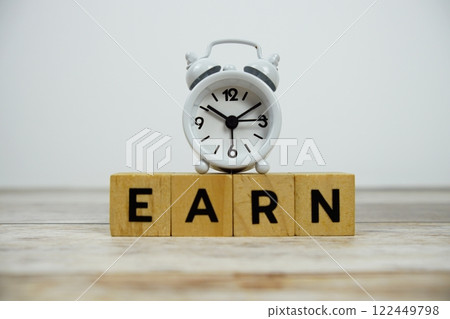 Time to Earn with wooden blocks alphabet letters and alarm clock on wooden background 122449798