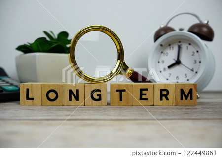 Magnifying glass and alarm clock with wooden blocks alphabet letters LONG TERM text message on wooden background Magnifying glass and alarm clock with wooden blocks alphabet letters LONG TERM text message on wooden background 122449861