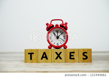 Time to Taxes with wooden blocks alphabet letters and alarm clock on wooden background Time to Taxes with wooden blocks alphabet letters and alarm clock on wooden background 122449862
