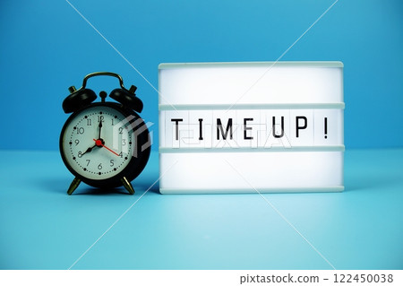 Time Up! letterboard text on LED Lightbox and alarm clock on blue background Time Up! letterboard text on LED Lightbox and alarm clock on blue background 122450038