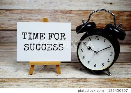 Time for Success text written on paper card with alarm clcok on wooden background Time for Success text written on paper card with alarm clcok on wooden background 122450807