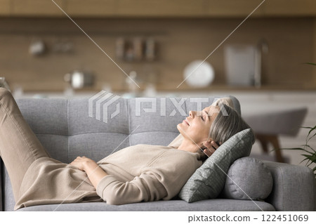 Calm serene early senior age lady sleeping on comfortable couch Calm serene early senior age lady sleeping on comfortable couch 122451069