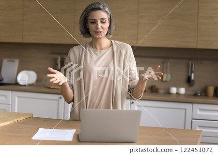 Aged lady freelancer speak to client online using notebook webcam Aged lady freelancer speak to client online using notebook webcam 122451072