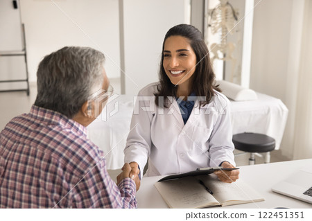Senior male shake hand of female doctor signing insurance policy Senior male shake hand of female doctor signing insurance policy 122451351