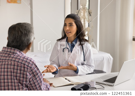 Confident young female doctor speak to elderly patient at hospital 122451361