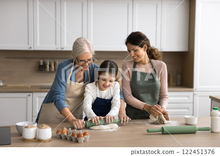 Older grandma young mum little girl cook pie at kitchen 122451376