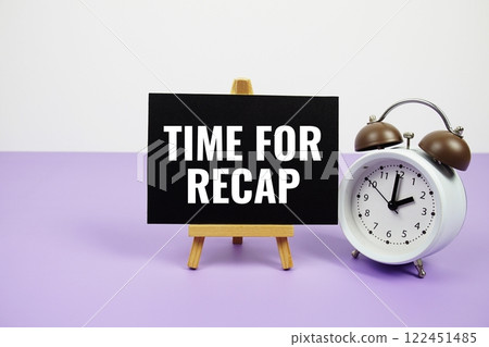 Time for Recap text on paper card with alarm clock on purple background Time for Recap text on paper card with alarm clock on purple background 122451485