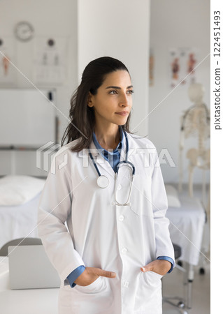 Pensive confident young female doctor stand in office look aside 122451493