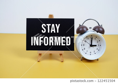 Stay Informed text on paper card with alarm clock on yellow background 122451504