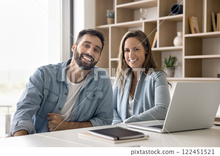 Portrait of two successful businesspeople posing together seated at table 122451521