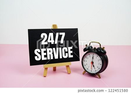 24/7 service text on paper card with alarm clock on pink background 122451580