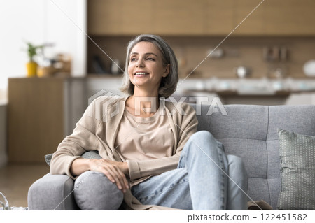 Attractive happy mature woman sit on sofa in relaxed pose 122451582