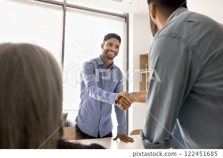 Young businessman greeting client, start negotiation in boardroom Young businessman greeting client, start negotiation in boardroom 122451685