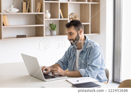 Young Hispanic businessman working on-line on project using laptop 122451686