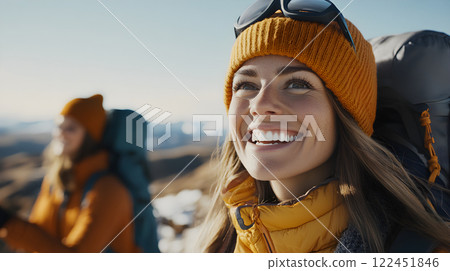 Traveler woman with backpack hiking on top of rocky peak. Snowy mountain landscape. Climber girl on summit. Active lifestyle, climbing, extreme sport concept. Background travel tourism vacations  122451846