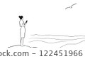 Woman using smartphone on the beach watching flying seagull 122451966