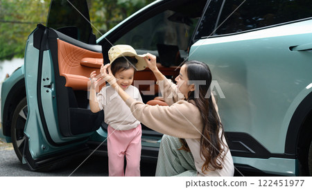 Loving mother putting a hat on her daughter preparing for an outdoor adventure 122451977