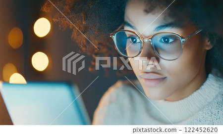 An office worker sits at a desk, blankly gazing at a smartphone with reflections visible in their glasses, internet addiction concept 122452620