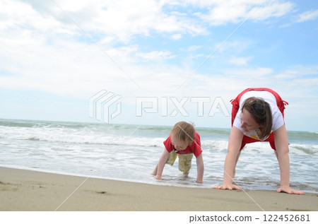 Mother and son playing on the shoreline. Summer enjoyment 122452681