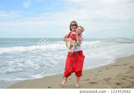Mother and son playing on the shoreline. Summer enjoyment 122452682